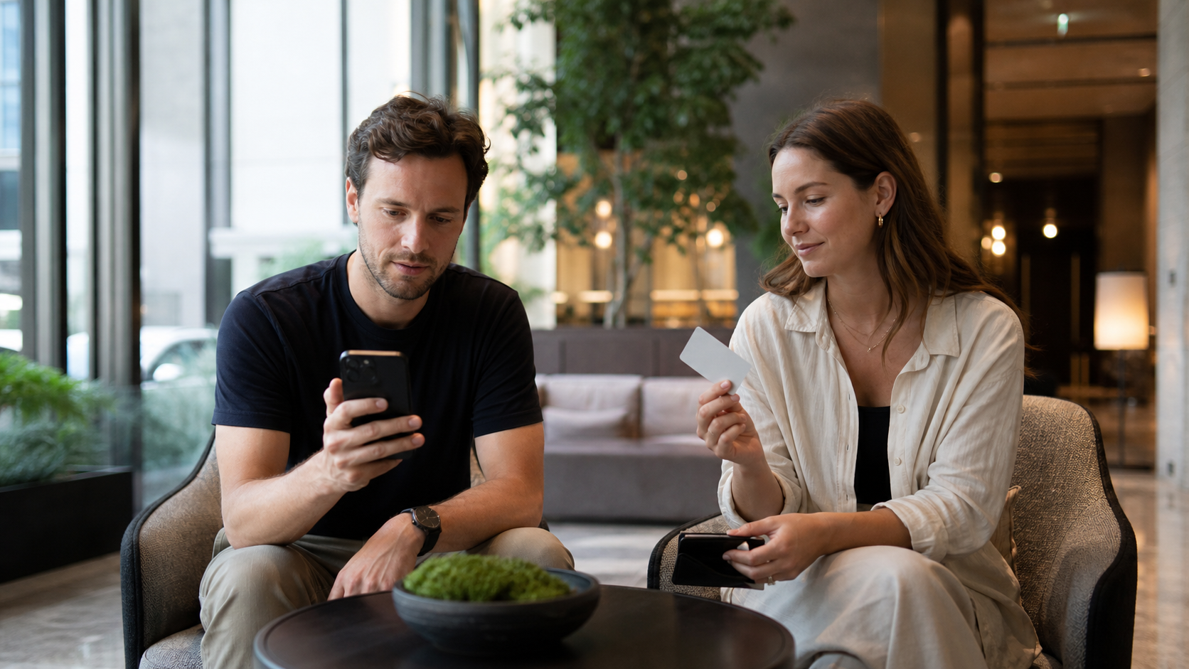 Two travelers comparing a phone and a physical transit card before leaving their hotel