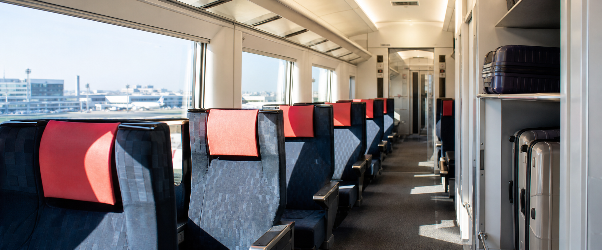 Bright reserved-seat interior and luggage storage on a Japanese airport express train